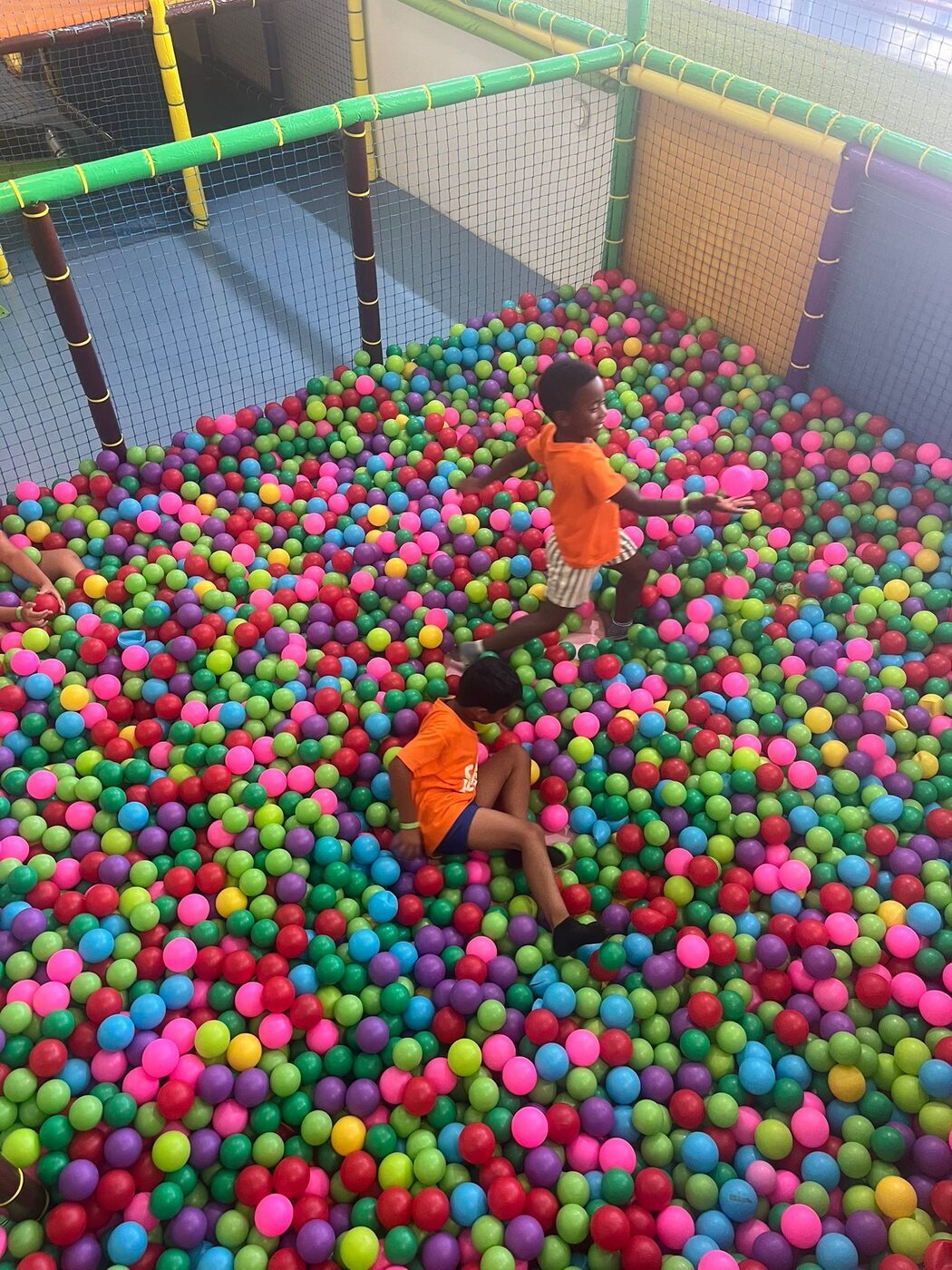 Crianças na piscina de bolas coloridas de um parque coberto