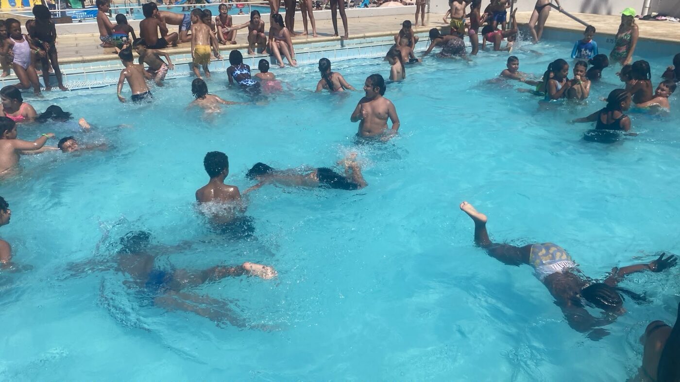 Crianças a nadar e a chapinhar na piscina
