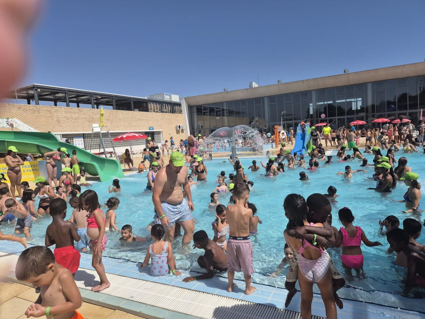 Parque aquático animado, com muitas crianças na água