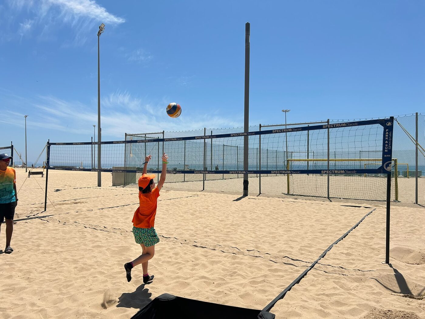 Jovem a saltar durante um jogo de voleibol de praia