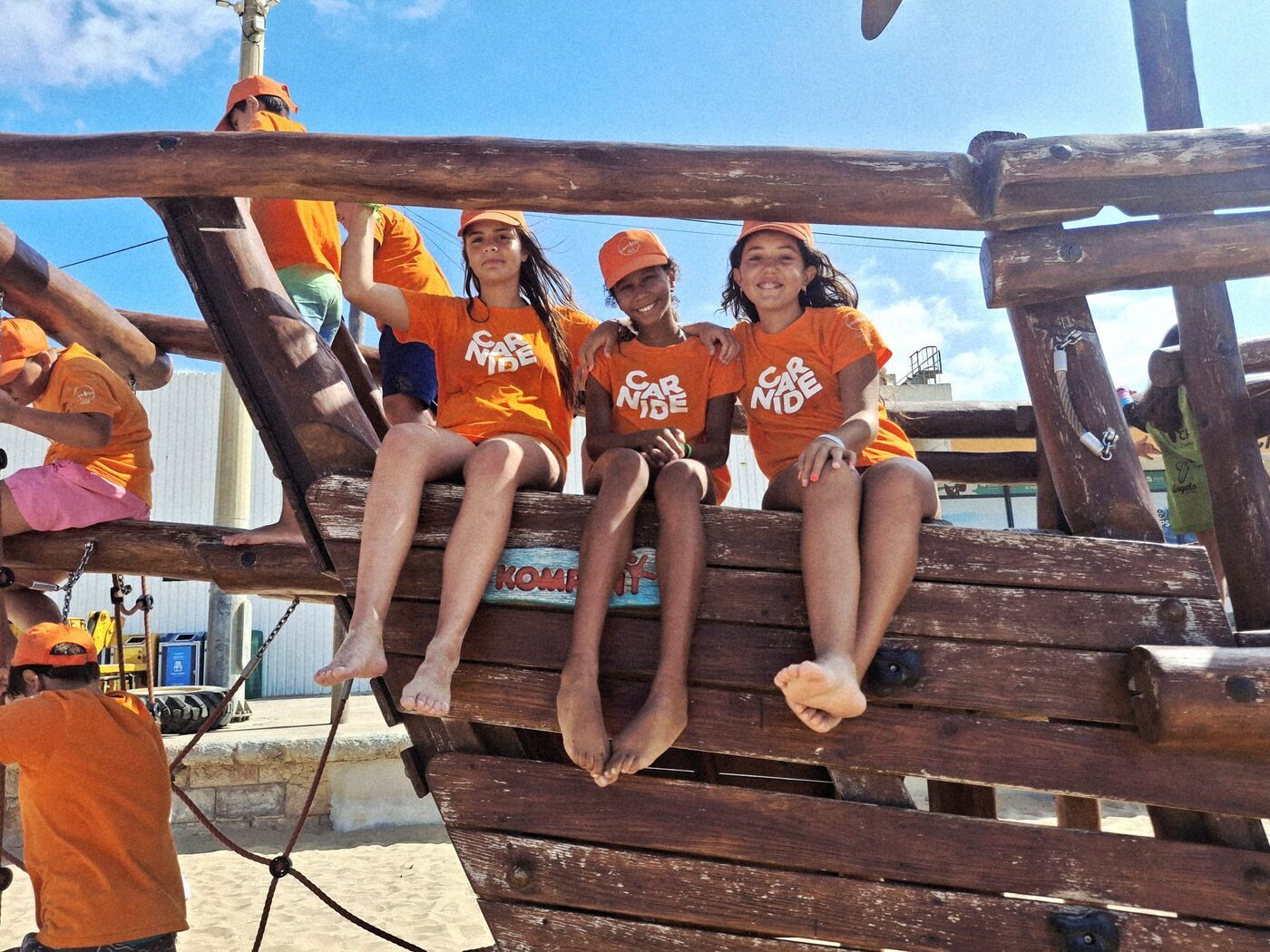 Crianças sentadas num barco pirata de madeira num parque infantil