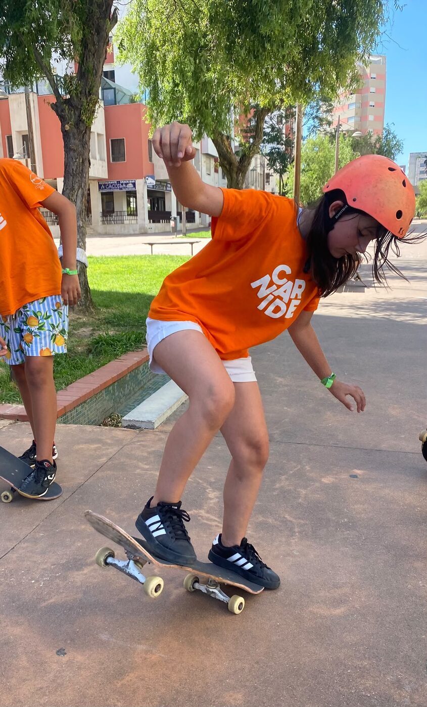 Rapariga de capacete a andar de skate num skatepark