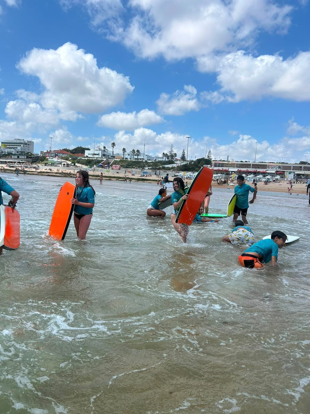 Crianças a apanhar ondas de bodyboard no mar