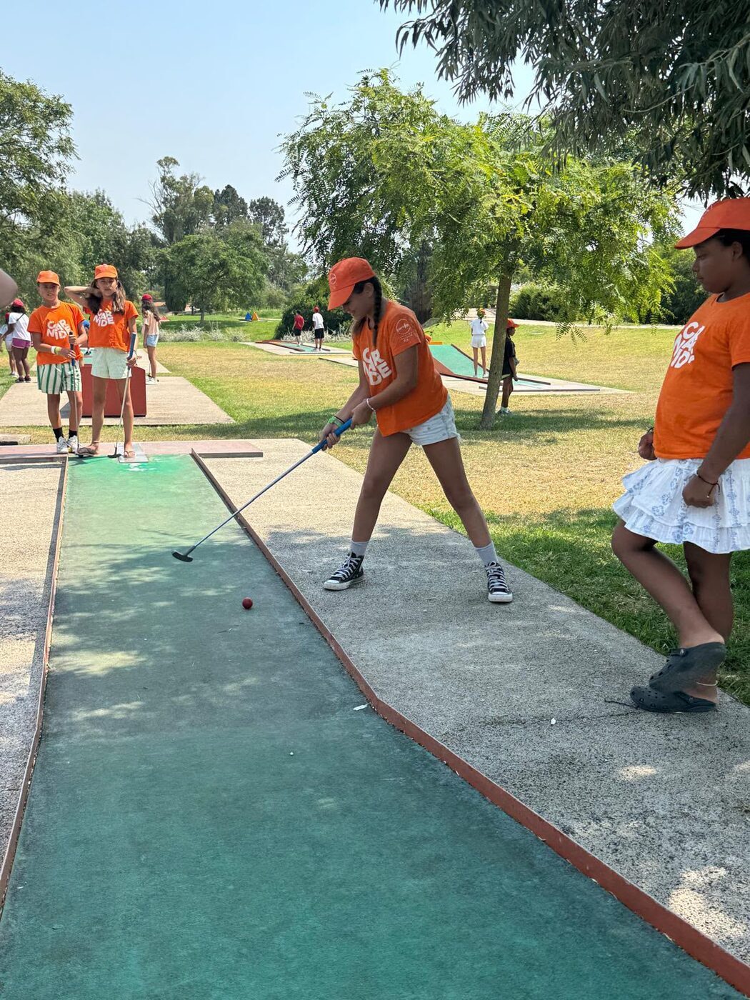 Criança a jogar minigolfe num parque