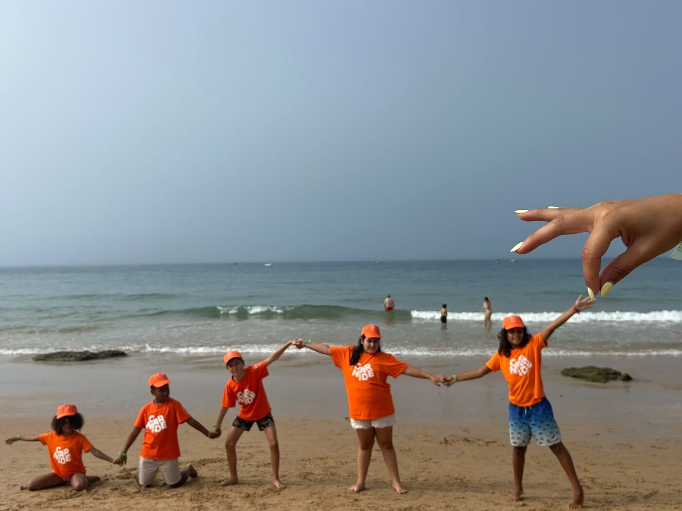 Crianças de mãos dadas na beira-mar