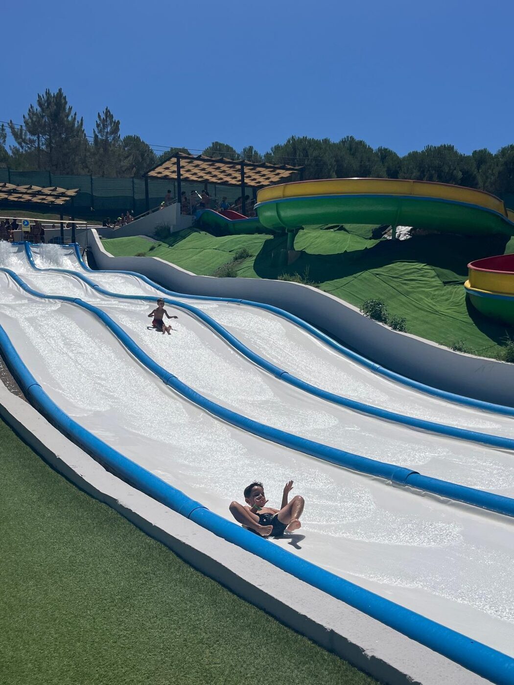 Escorregas de um parque aquático, com uma criança a descer