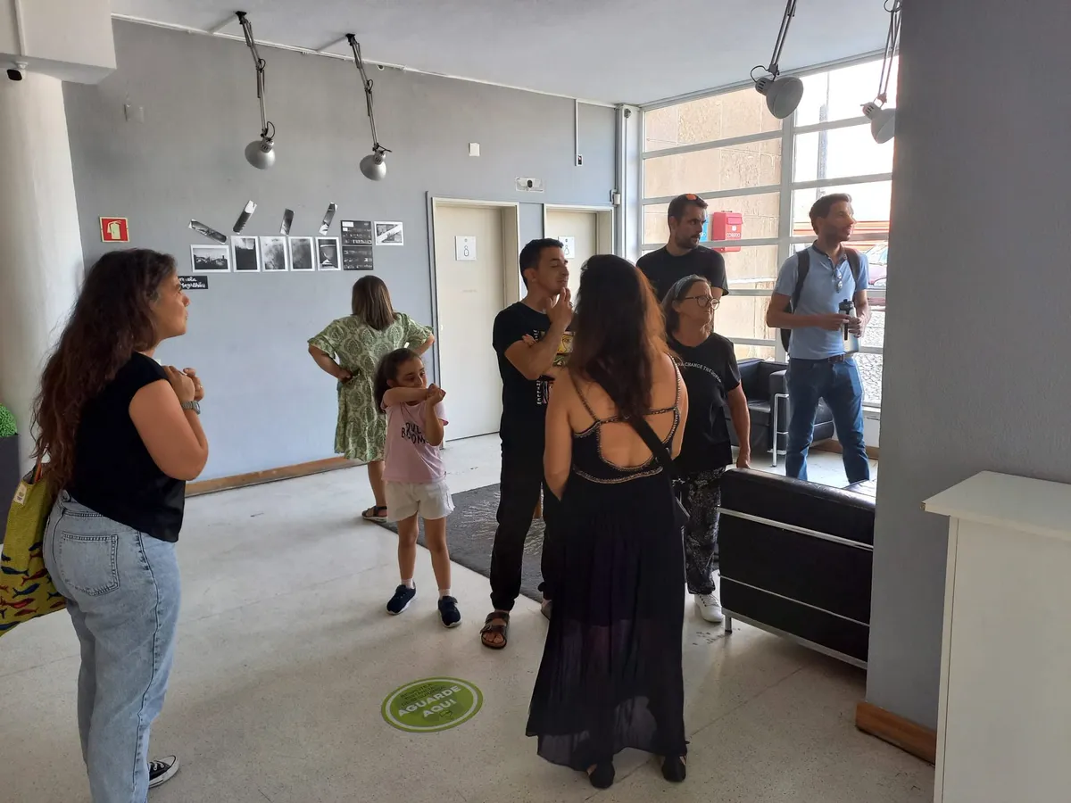 Foyer do Centro Cultural com exposição de fotografias nas paredes e visitantes