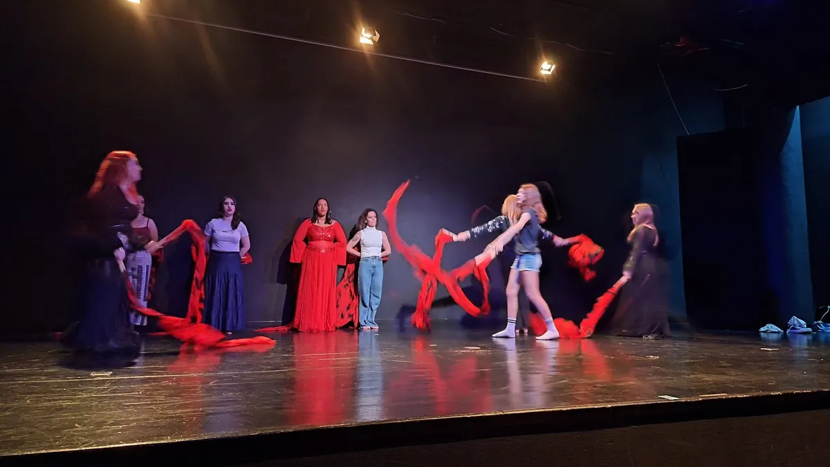 Bailarinos com tecidos vermelhos e azuis no palco do auditório