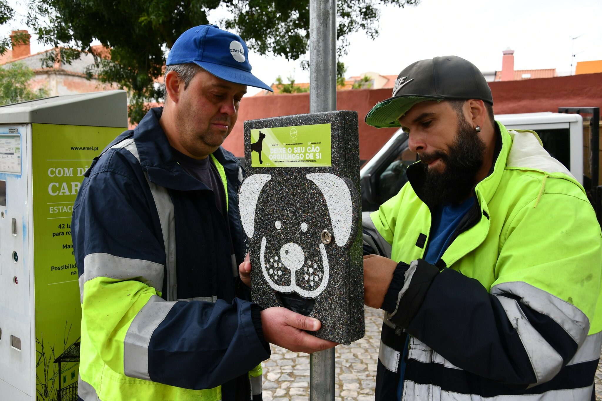 Dois trabalhadores a instalar dispensador canino