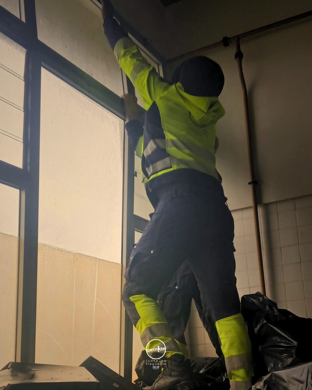 Trabalhador a intervir numa janela danificada no interior de um edifício